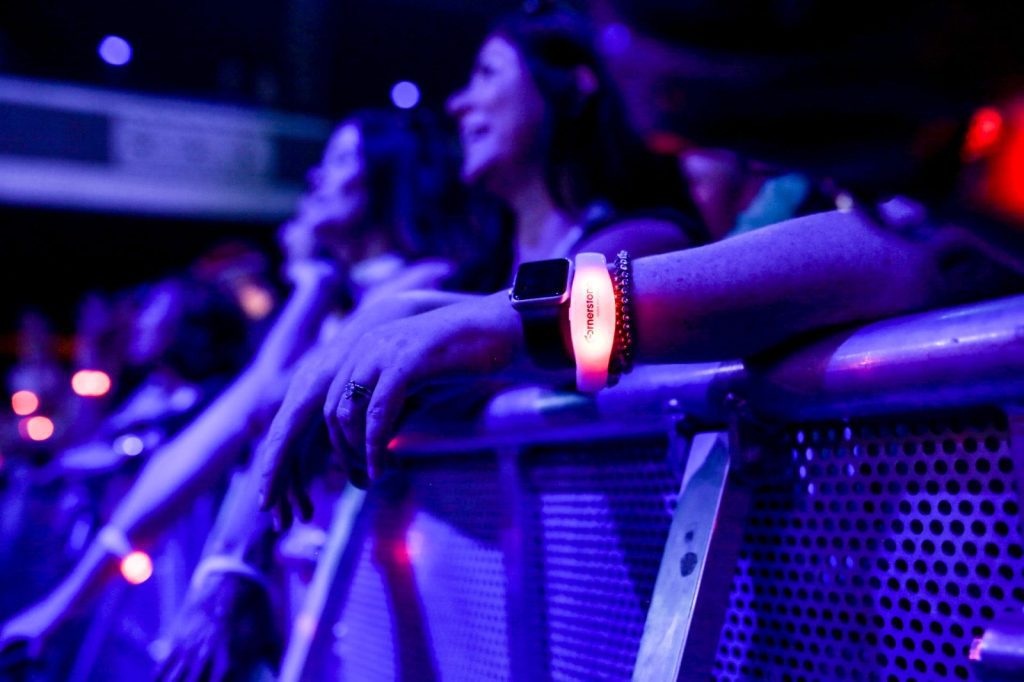 Colorful Xyloband wristbands lighting up a large event crowd during a live show